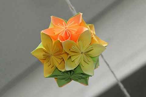 Fleurogami-Kugel aus Papier mit roten, gelben und grünen Blüten